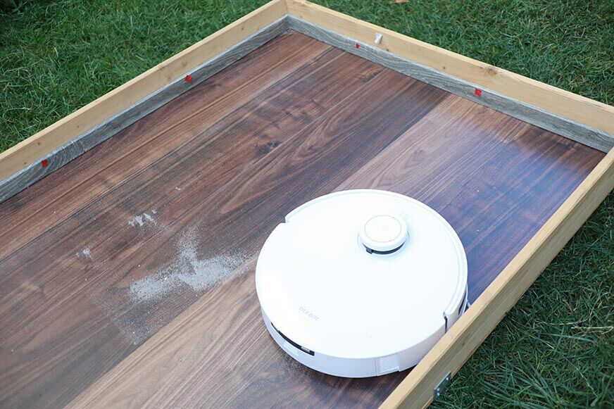 Ecovacs Deebot T10 reinigt im Test Sand auf einem Hartboden.